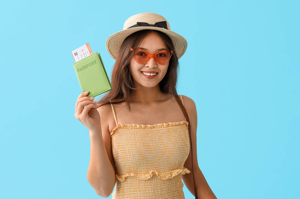 Piękna młoda kobieta posiadająca paszport i bilet na tle koloru - Zdjęcie, obraz