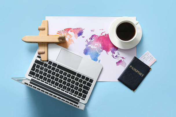 Composition with modern laptop, passport, world map and cup of coffee on color background - Photo, Image