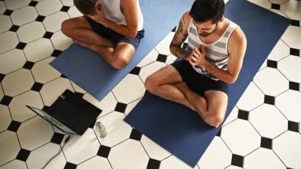 Ordenador portátil, yoga amigos y hombres en el apartamento para la salud y el bienestar con ejercicio en la sala de estar. Clase en línea, meditación para la atención plena y vista superior con zen espiritual en pose de loto en casa. - Imágenes, Vídeo