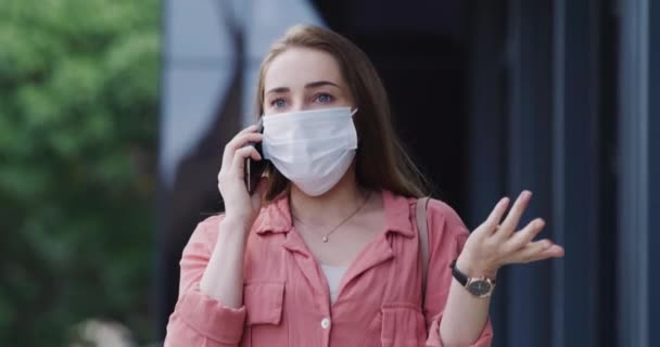 Sledujte, telefonujte a ženy ve městě s obličejovou maskou, aby se zabránilo bakteriím, bakteriím nebo nemocem. Pozdě, komunikace a mladý člověk s ochranou na mobilní konverzaci s mobilním telefonem v městském městě. - Záběry, video