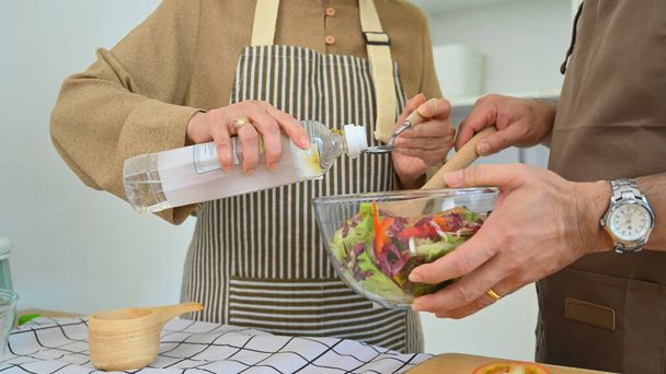 Rentnerehepaar kocht in Küche gemeinsam gesunde vegane Mahlzeit mit Gemüse. - Foto, Bild