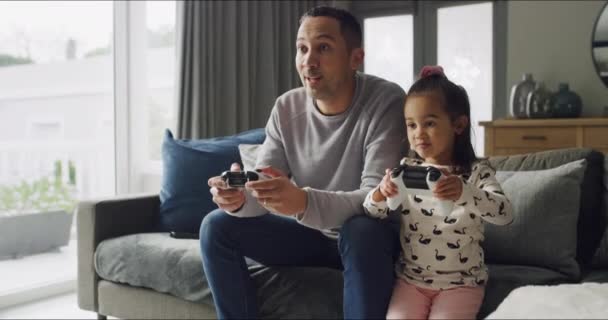 A győztes, a gyerek és az apa együtt videojátékoznak a nappaliban, hogy megnyerjék a versenyt a kanapén. Technológia, lány és apa ünneplés vezérlő, konzol szórakoztató vagy izgatott családi ölelés. - Felvétel, videó