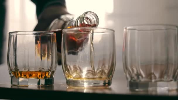 Whiskey öntött az üvegbe elegánsan. Whiskey öntött az üvegbe elegánsan. Egy közeli kép borostyánsárga whiskyről, amit tiszta pohárba öntenek. - Felvétel, videó