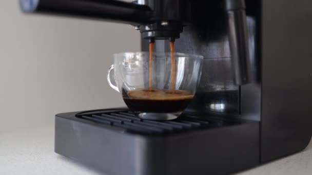 Koffiemachine vult een kopje mee. Koffie zetten met een koffiezetapparaat in een kopje, espresso koffie die uit een automatische koffiezetapparaat komt. Drankje als ontbijt. Hoge kwaliteit FullHD beeldmateriaal - Video