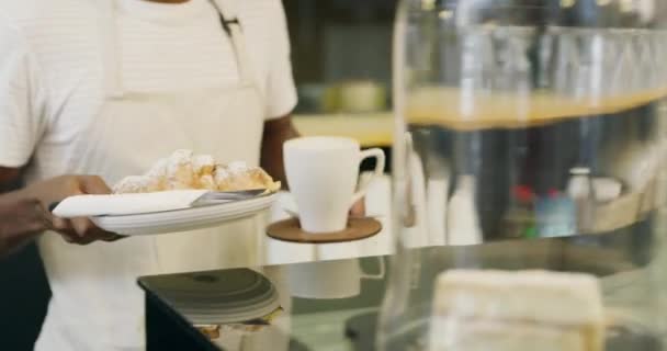 Pekárna, káva a ruce s croissant na talíři od číšníka, servis a produkt v restauraci nebo kavárně. Malý byznys, zaměstnanec a dávat osobě espresso, čaj a dezert na stole k zákazníkovi. - Záběry, video
