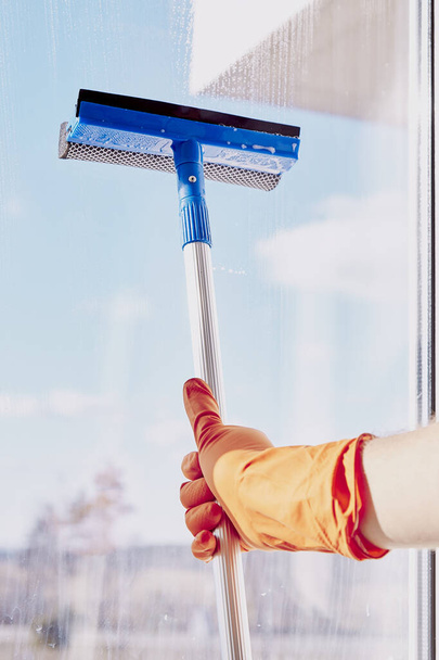 Concept de nettoyage de printemps. L'homme lave les fenêtres le jour ensoleillé. Les tâches ménagères. Désinfection en quarantaine due au coronavirus - Photo, image