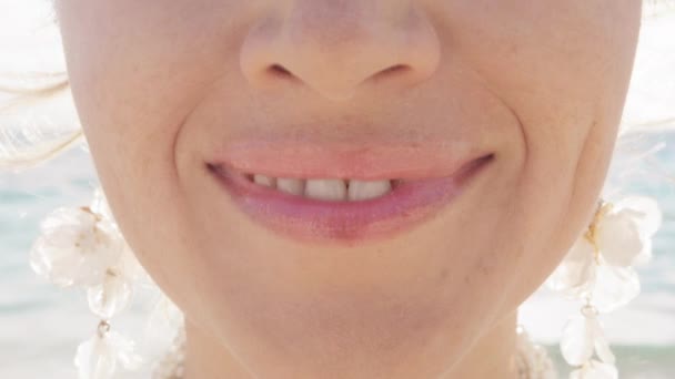 Крупный план женщина показывает белую улыбку после невидимой процедуры выравнивания зубов на открытом солнечном фоне. Концепция стоматологии и стоматологии. Счастливая белая женщина улыбается в камеру в замедленной съемке 4К - Кадры, видео