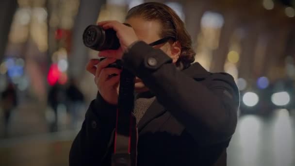 Mannelijke reiziger neemt foto 's op drukke stedelijke straat' s nachts - Video