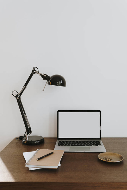 Minimalistischer Schreibtisch im Home Office mit Laptop, Lampe auf dem Tisch. Vorderseite Kopierraum leer Attrappe nach oben Vorlage - Foto, Bild