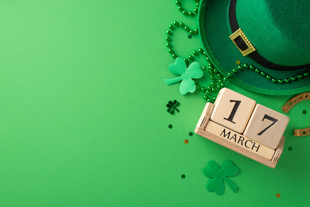 St. Paddy juhlallisuudet yhdessä kehyksessä: ylhäältä näkymä puinen kalenteri, menninkäinen hattu, onnekas hevosenkenkä, trefoils, konfetti, ja helmiä vihreällä taustalla tekstitilaa - Valokuva, kuva