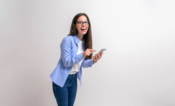 Πορτρέτο της γυναίκας επιχειρηματία γέλιο και γραπτών μηνυμάτων πάνω από έξυπνο τηλέφωνο σε απομονωμένο λευκό φόντο - Φωτογραφία, εικόνα
