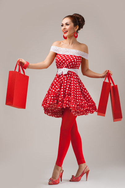 Happy Woman Holding Up Shopping Bags. Pin-up retro style. - Фото, изображение