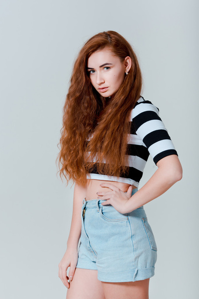 Portrait of beautiful sexy young rude girl in jeans shorts  - Foto, afbeelding