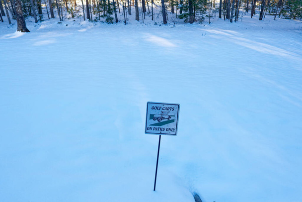 Golfcarts auf Wegen nur Beschilderung entlang des Weges in einem schneebedeckten Golfplatz im Schatten im Winter - Foto, Bild