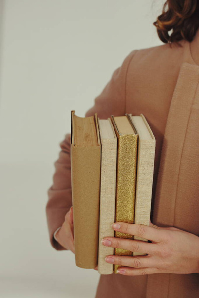 une fille tient une pile de livres dans ses mains - Photo, image