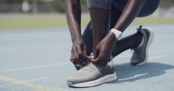 Person, runner and tie shoelace in stadium or starting line for exercise safety, speed or competition. Athlete, feet and hands on field as sprinter or sport training health, marathon or challenge. - Кадры, видео