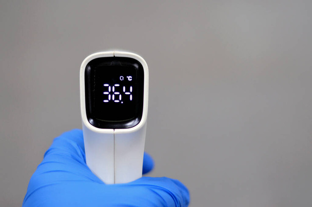 Berührungsloses Infrarot-Thermometer, ein Thermometer, das die Temperatur aus einem Teil der Wärmestrahlung ableitet, der manchmal als Schwarzkörperstrahlung, berührungslose Thermometer oder Temperaturpistolen bezeichnet wird - Foto, Bild