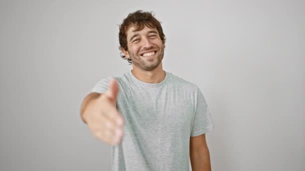 Vriendelijke, succesvolle jonge man in een casual t-shirt, begroeting met een gastvrije handdruk, zijn extatische glimlach stralend succes. op een witte, geïsoleerde achtergrond. - Video