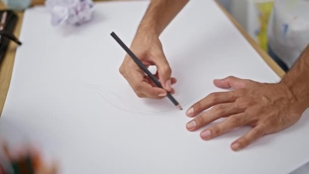 Mani di uomo ispanico disegno con fervore in studio d'arte, abbozzando la vita su carta con la matita - Filmati, video
