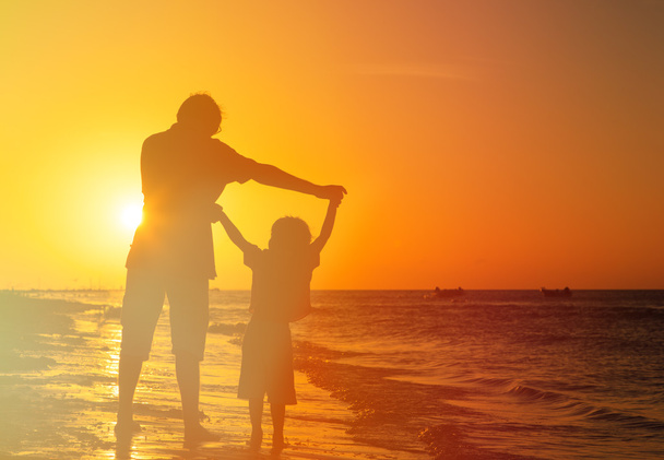 père et fils jouent à la plage du coucher du soleil
 - Photo, image