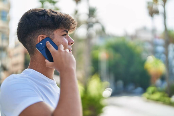 Νέοι Ισπανοί έφηβοι μιλούν στο smartphone με χαλαρή έκφραση στο δρόμο - Φωτογραφία, εικόνα