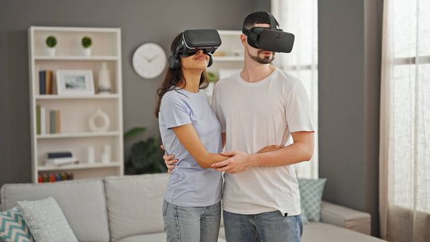 Gyönyörű pár megosztása szerelem, játék együtt vr szemüveg otthon, feltárása futurisztikus cyber világ, mosolygós és ölelés a hangulatos nappaliban. - Fotó, kép