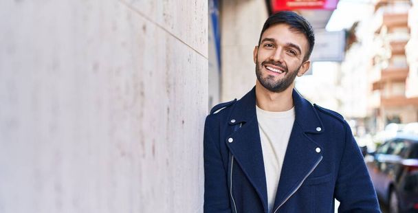 Nuori latino mies hymyilee luottavainen seisoo kadulla - Valokuva, kuva