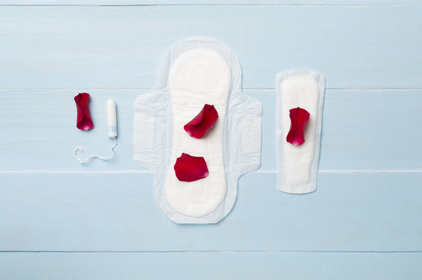 Menstruatie hygiëneproducten op houten ondergrond, bovenaanzicht - Foto, afbeelding