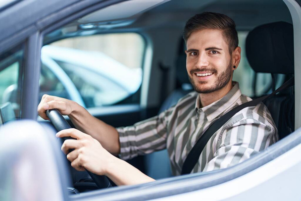 Spanyol férfi szakállas vezetés autó néz pozitív és boldog álló és mosolygó magabiztos mosollyal mutatja fogak  - Fotó, kép
