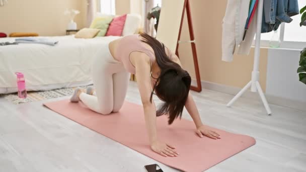 Mladá Asiatka se natahuje na podložku na jógu v útulném, stylově zařízeném pokoji. - Záběry, video