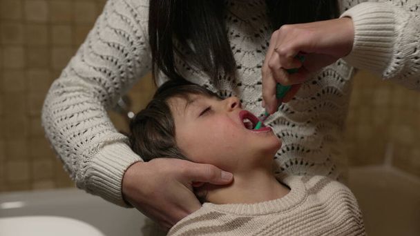 Мати чистить зуби дитини перед сном. сплячий режим ввечері перед сном. дитяча гігієна зубів - Фото, зображення