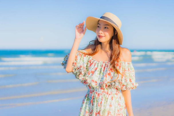 Portrét krásný mladý asijské žena šťastný úsměv relax kolem tropické pláže moře oceán na modré obloze pro volný čas - Fotografie, Obrázek