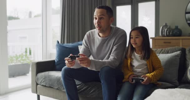 Святкування, дитина і батько грають відеоігри в домашній вітальні разом для змагань перемоги на дивані. Технології, тато і дівчина з переможцем на контролері, розваги та захоплені обійми сім'ї. - Кадри, відео