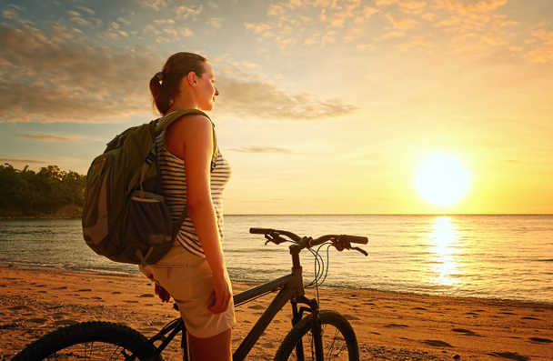 Chica viajero con mochila disfrutando de la vista de la hermosa puesta de sol
.  - Foto, imagen