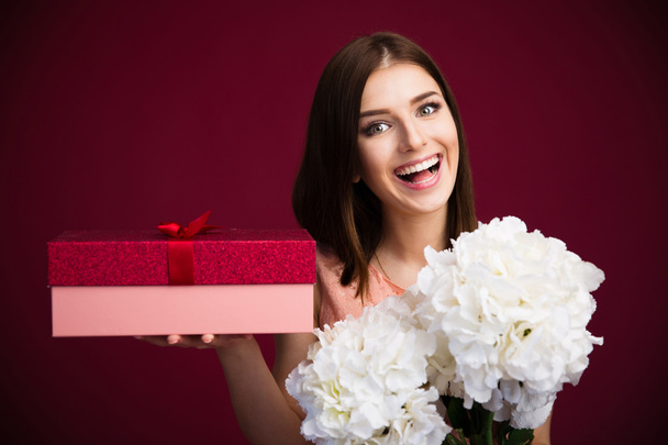 lächelnde süße Frau mit Geschenkbox und Blumen - Foto, Bild