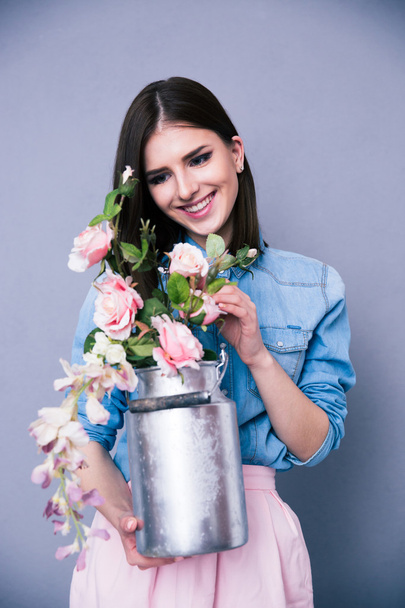 Smiling young cute woman holding flowers - Fotoğraf, Görsel