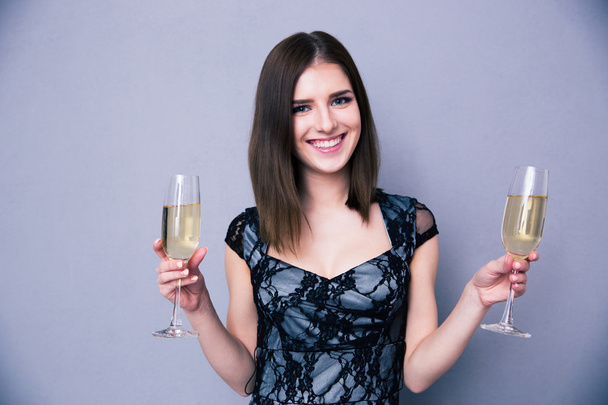 Smiling woman holding two glass of champagne - Photo, image