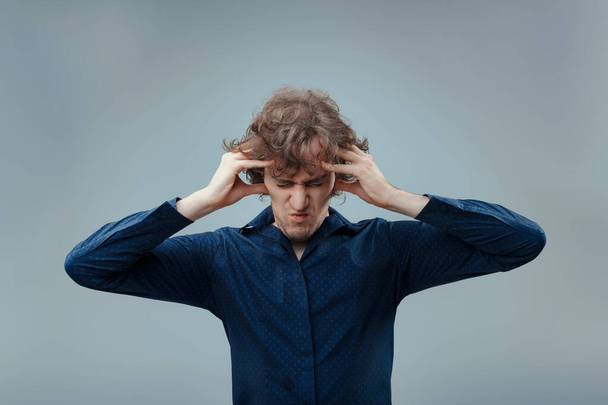 Stresszes férfi göndör haj markolja fejét látható frusztráció, szem becsukva kellemetlen - Fotó, kép