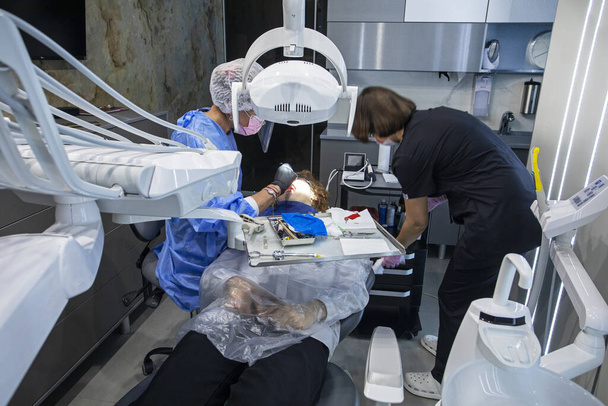стоматолог и ассистент во время лечения у пациента - Фото, изображение