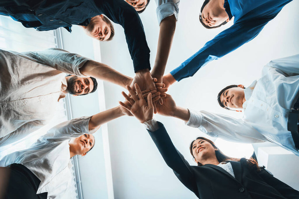 Vue du bas spirale main ronde faite par divers employés de bureau ou gens d'affaires unissent main symbolisent la synergie d'affaires ou partenariat de confiance. Collectif et unité en milieu de travail. Prudent - Photo, image