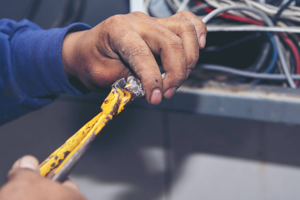 Inspector men hands working switchboard machinery maintenance service. Electrical mechanic technician check wire electric cabinet.  Electrician circuit repair voltage operation. Men hands fix breaker - Photo, Image