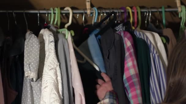 Жінка, дивлячись в гардероб для чогось носити середній 4k постріл вибірковий фокус - Кадри, відео
