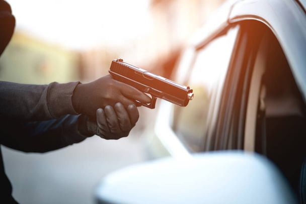 泥棒は車を盗むために銃を使用しています, 車のキーを持つ女性を脅かす - 写真・画像