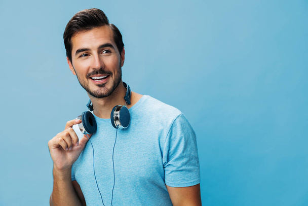 Muž šťastný životní styl modrý ven zábava mluvení těšit portrét sluchátka hudba studio kopírovat t-shirt emotion prostor zpívat online střih pozadí - Fotografie, Obrázek