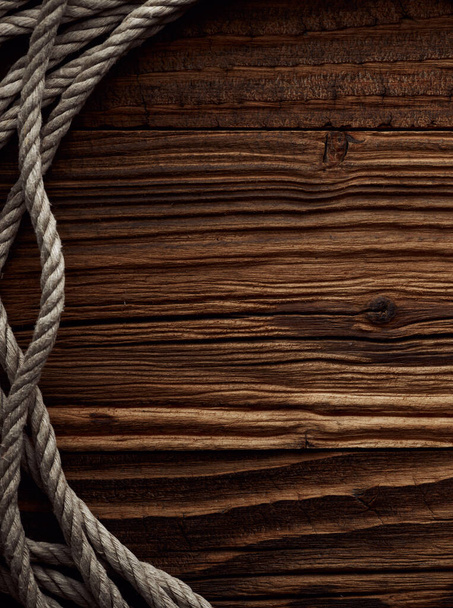 Fondo marino vintage oscuro con cuerda de cáñamo viejo sobre tablones de madera - Foto, Imagen