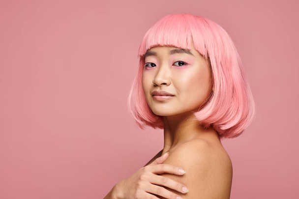 gentle asian young girl with nose piercing, pink hair and makeup against vibrant background - Foto, Bild