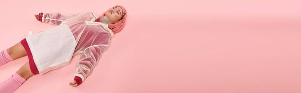 banner of young woman with silver necklace, pink hair and makeup lying down on vibrant background - Foto, immagini
