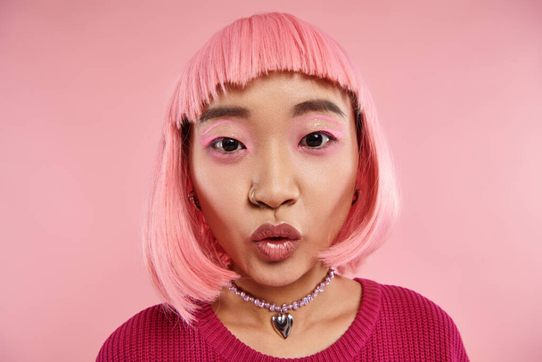 крупним планом мила азіатська жінка в 20-х з пірсингом носа і рожевим волоссям дивує і дивиться на камеру - Фото, зображення