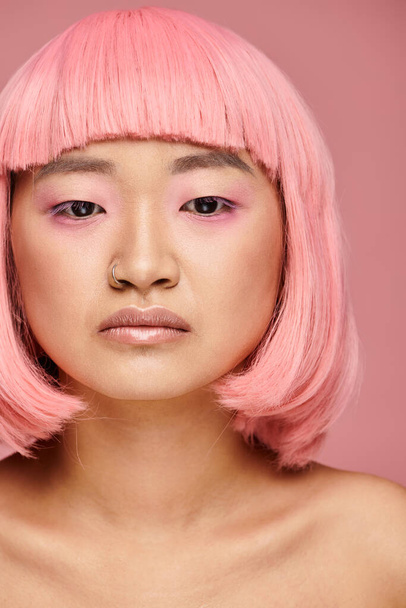 gyönyörű fiatal nő rózsaszín haj néz le ellen élénk háttér - Fotó, kép