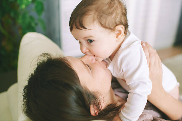 Sisäuima muotokuva onnellinen nuori äiti leikkii ihana vauva, puree lapsi, hampaiden aika - Valokuva, kuva